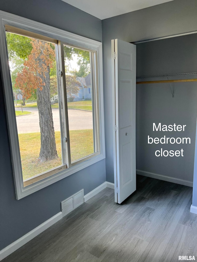 unfurnished bedroom featuring a closet and dark hardwood / wood-style floors