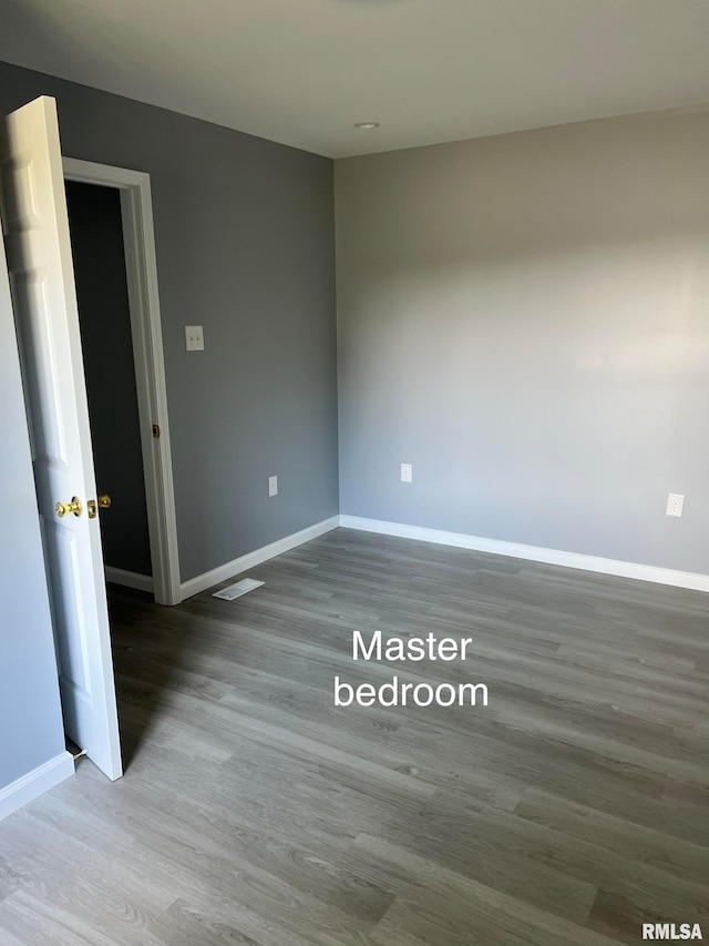 unfurnished room with dark wood-type flooring