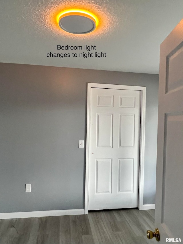 hallway with a textured ceiling and dark hardwood / wood-style flooring