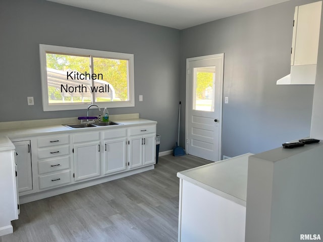 kitchen featuring light hardwood / wood-style flooring, sink, and white cabinetry