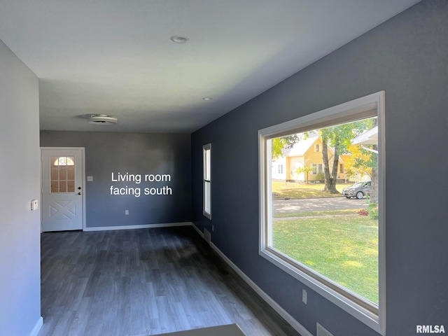 unfurnished room with dark wood-type flooring