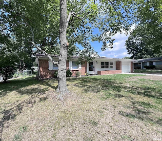 ranch-style house with a front lawn, brick siding, fence, and an attached garage