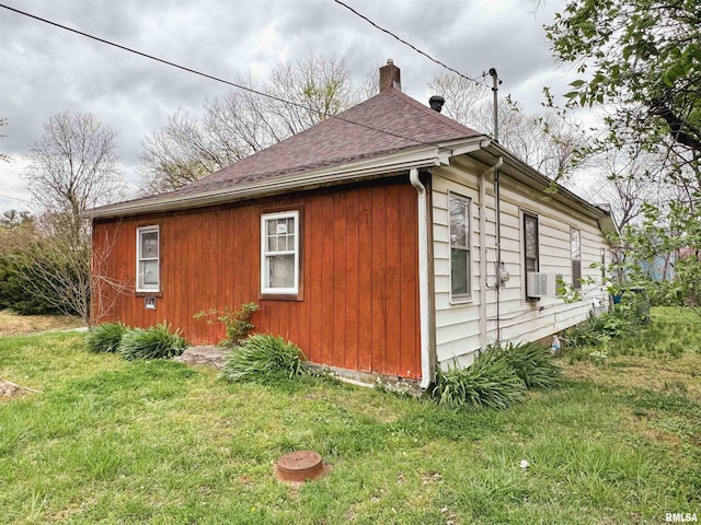 view of home's exterior featuring roof with shingles, a chimney, and a yard