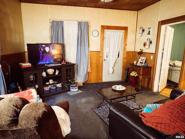 carpeted living area with wooden walls, wainscoting, and wallpapered walls