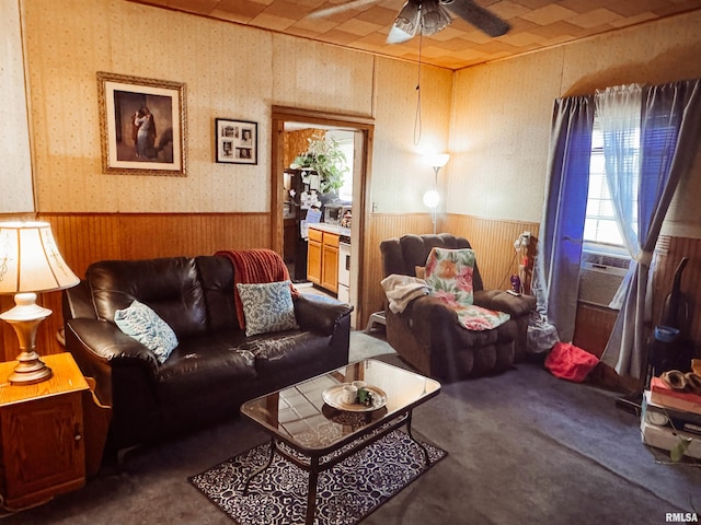 living area with wallpapered walls, cooling unit, a wainscoted wall, wood walls, and ceiling fan