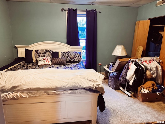 bedroom with a paneled ceiling and carpet