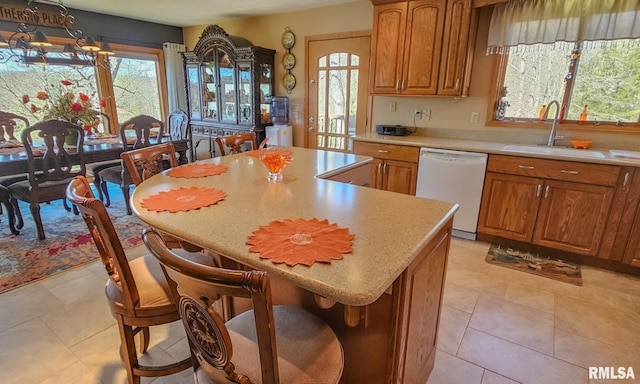 kitchen featuring sink, a center island, dishwasher, and plenty of natural light