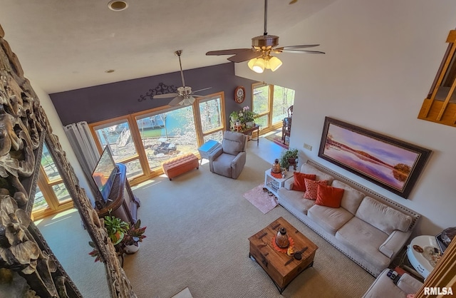 carpeted living room featuring ceiling fan and high vaulted ceiling