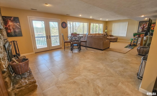 tiled living room featuring a textured ceiling and french doors