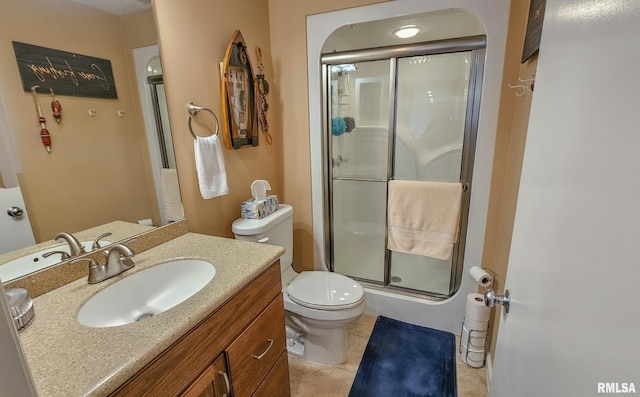 bathroom with tile flooring, toilet, vanity, and a shower with door