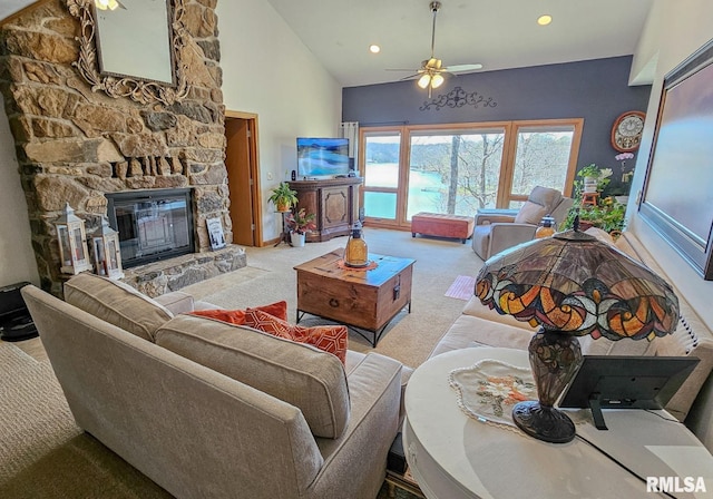 carpeted living room featuring ceiling fan, a fireplace, and high vaulted ceiling