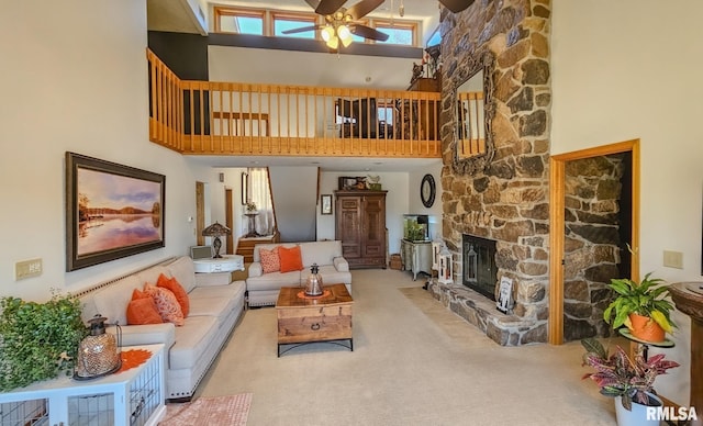 carpeted living room with a fireplace, ceiling fan, and a towering ceiling