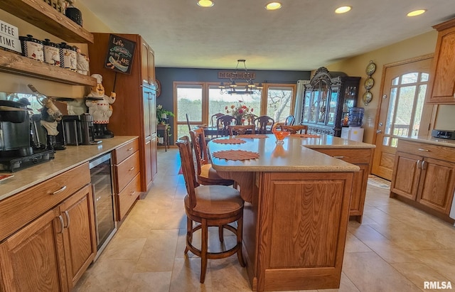 kitchen featuring a kitchen island, a breakfast bar, hanging light fixtures, and light tile floors