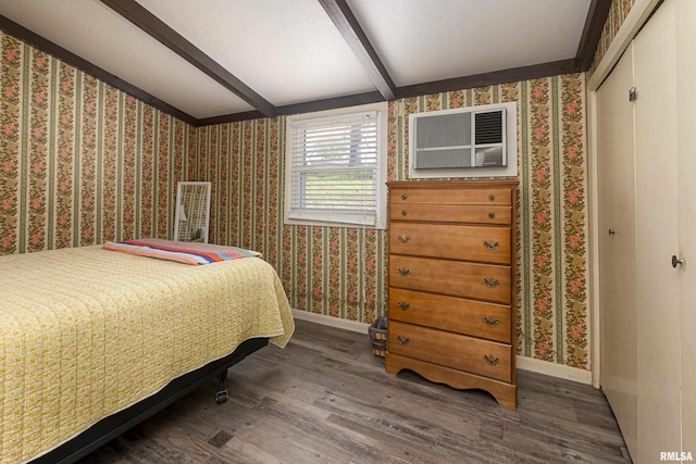 bedroom featuring a closet, beamed ceiling, and dark wood-type flooring