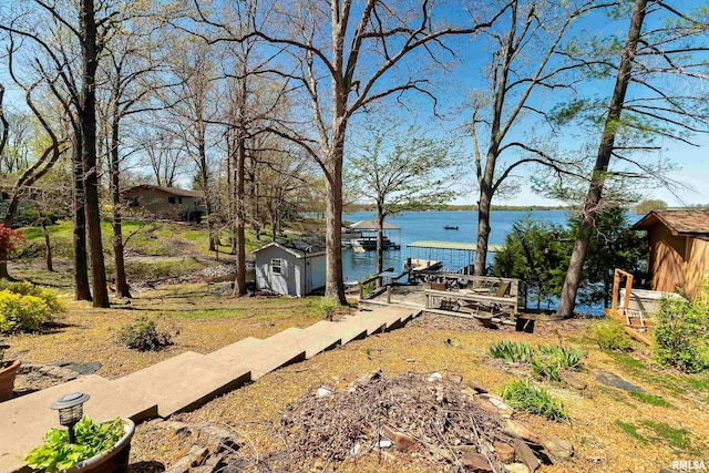 view of yard featuring a water view and a dock