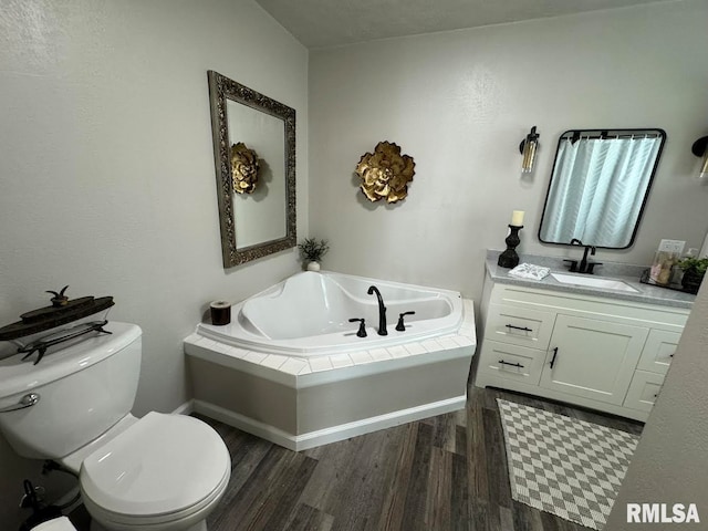 bathroom featuring hardwood / wood-style floors, vanity, toilet, and a washtub