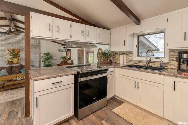 kitchen featuring sink, vaulted ceiling with beams, wood-type flooring, stainless steel electric stove, and white cabinets