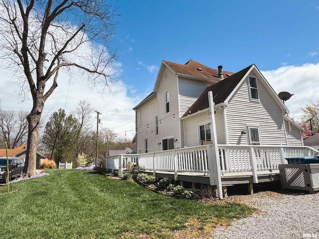 view of side of home with a wooden deck and a lawn