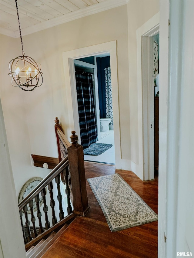 hallway with wood ceiling, crown molding, hardwood / wood-style floors, and a chandelier