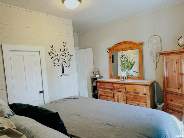 bedroom featuring wooden walls