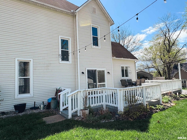 back of property with a yard and a deck