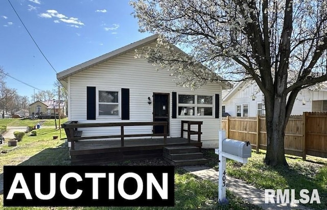 view of front facade with a wooden deck and a front lawn