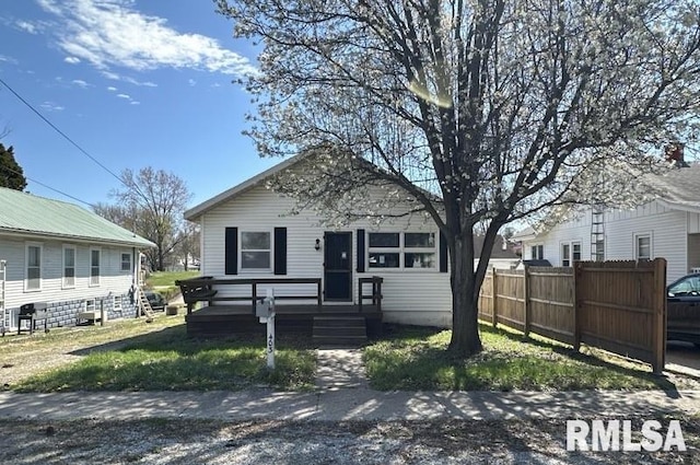 rear view of property with a wooden deck and a lawn