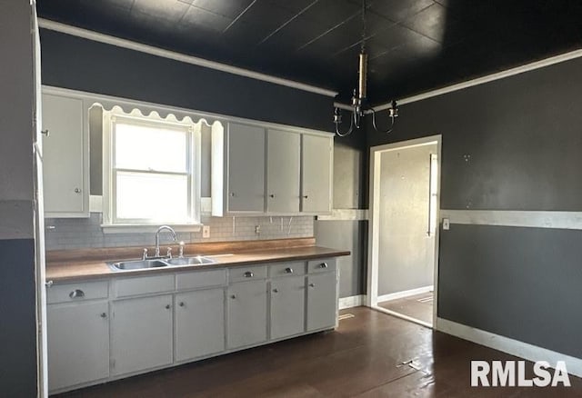 kitchen featuring tasteful backsplash, sink, dark hardwood / wood-style flooring, and white cabinets