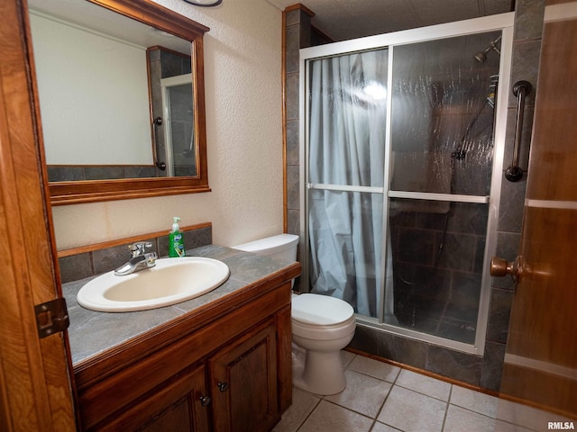 bathroom featuring a shower with door, vanity, toilet, and tile patterned floors