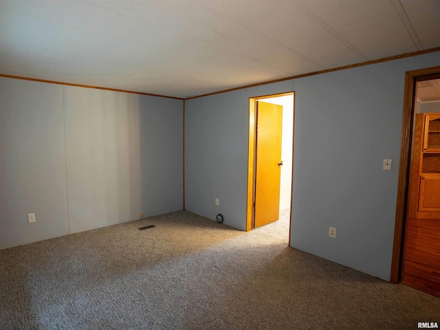 unfurnished room with carpet and crown molding