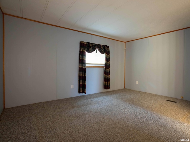 empty room with ornamental molding and carpet floors