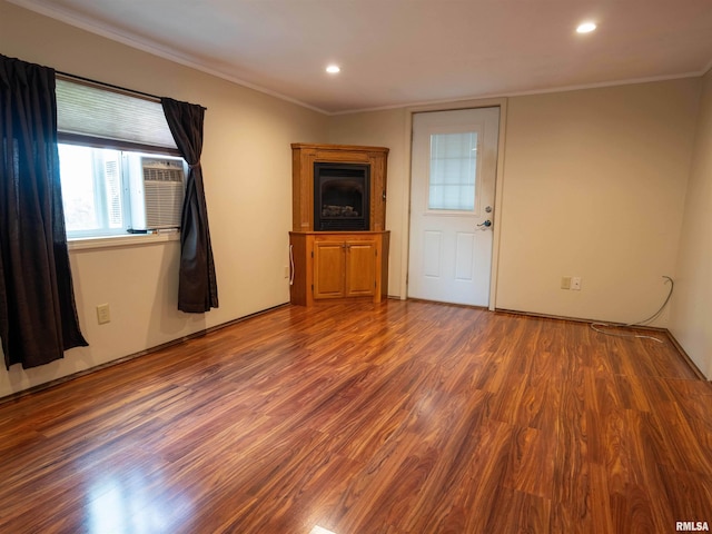 unfurnished living room featuring dark wood-type flooring, cooling unit, and crown molding