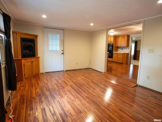 unfurnished living room with ornamental molding and dark hardwood / wood-style flooring