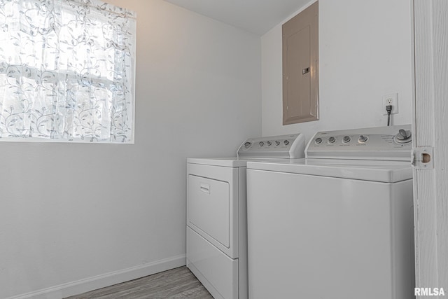 clothes washing area with light hardwood / wood-style floors and washer and clothes dryer