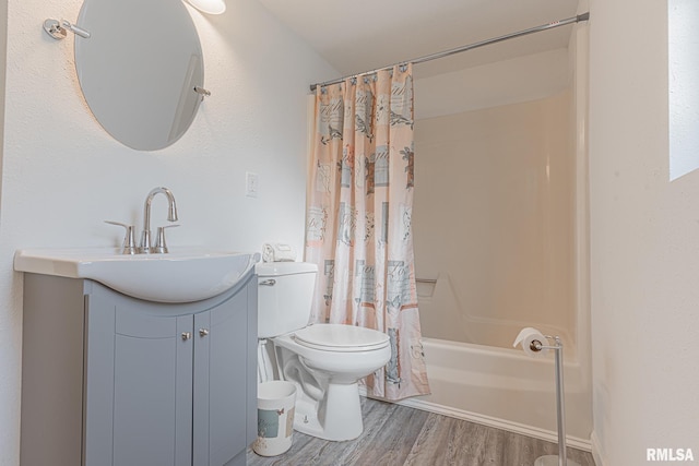 full bathroom with vanity with extensive cabinet space, toilet, shower / bath combo with shower curtain, and hardwood / wood-style floors