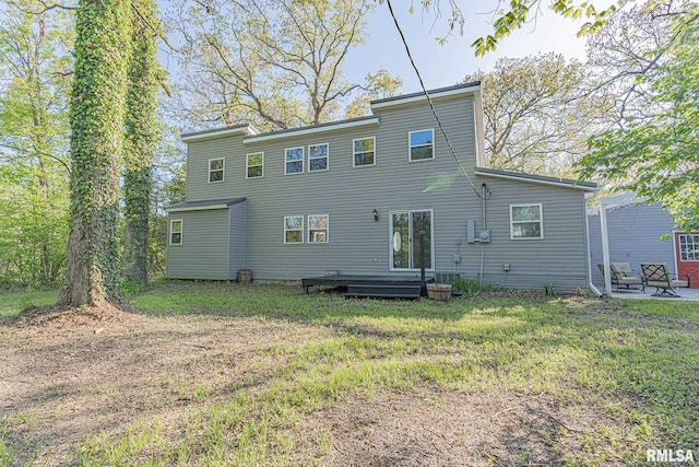 back of house with a patio and a lawn