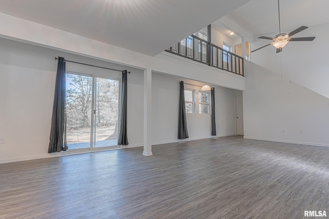 spare room featuring hardwood / wood-style flooring, ceiling fan, and a high ceiling