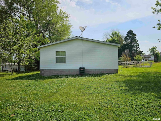 view of side of home with a lawn and central AC unit