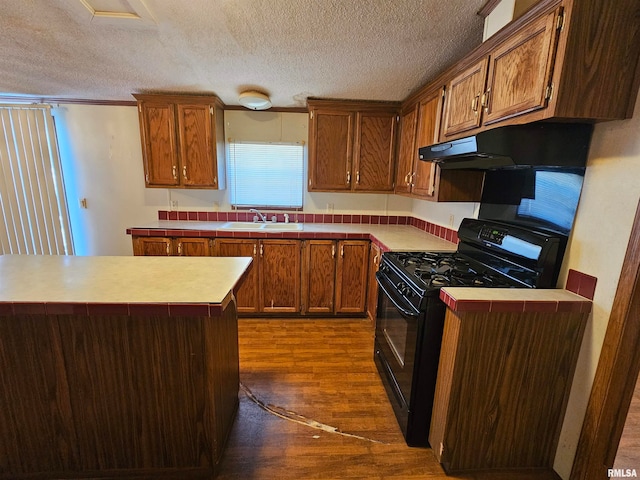 kitchen with dark hardwood / wood-style floors, sink, black gas stove, and a textured ceiling