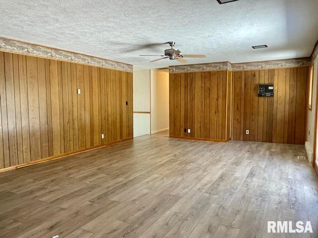 unfurnished room featuring wood-type flooring, a textured ceiling, and ceiling fan