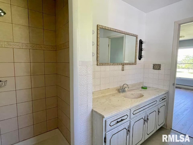 bathroom featuring wood-type flooring, vanity, and tile walls