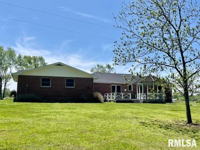 rear view of property featuring a yard