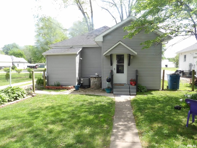 bungalow-style home featuring central AC and a front yard