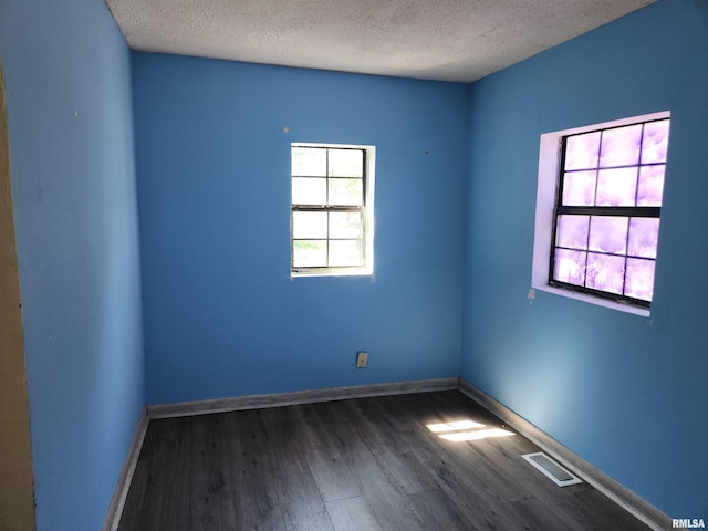 spare room featuring a textured ceiling and hardwood / wood-style floors