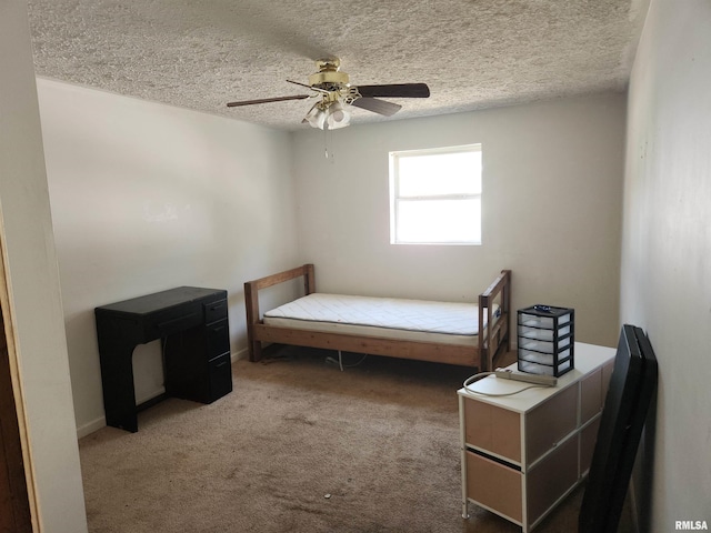 bedroom featuring ceiling fan, carpet flooring, and a textured ceiling