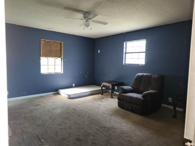 unfurnished room with ceiling fan, a textured ceiling, and carpet flooring