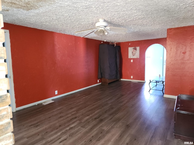 empty room featuring a textured ceiling and dark wood-type flooring