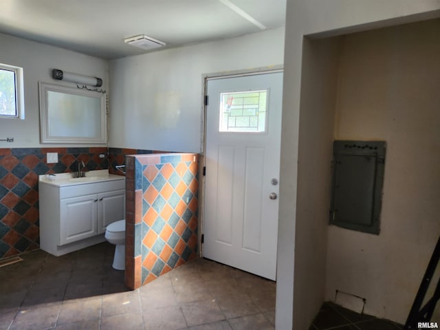 bathroom with tile patterned floors, vanity, electric panel, and toilet