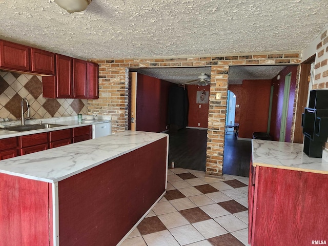 kitchen featuring ceiling fan, a textured ceiling, sink, and backsplash