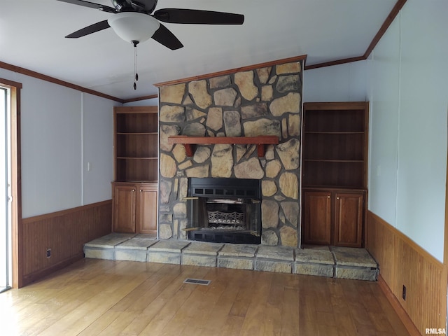 unfurnished living room with vaulted ceiling, light hardwood / wood-style flooring, crown molding, and a fireplace